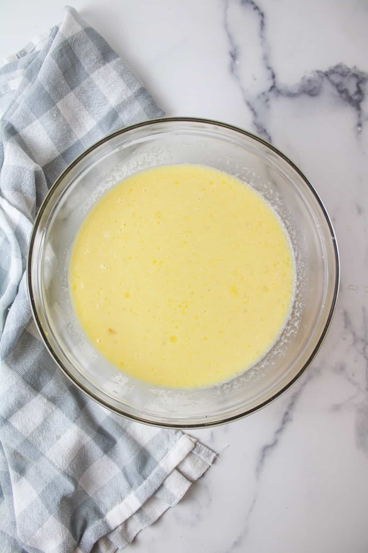 a mixture of eggs and milk in a mixing bowl.