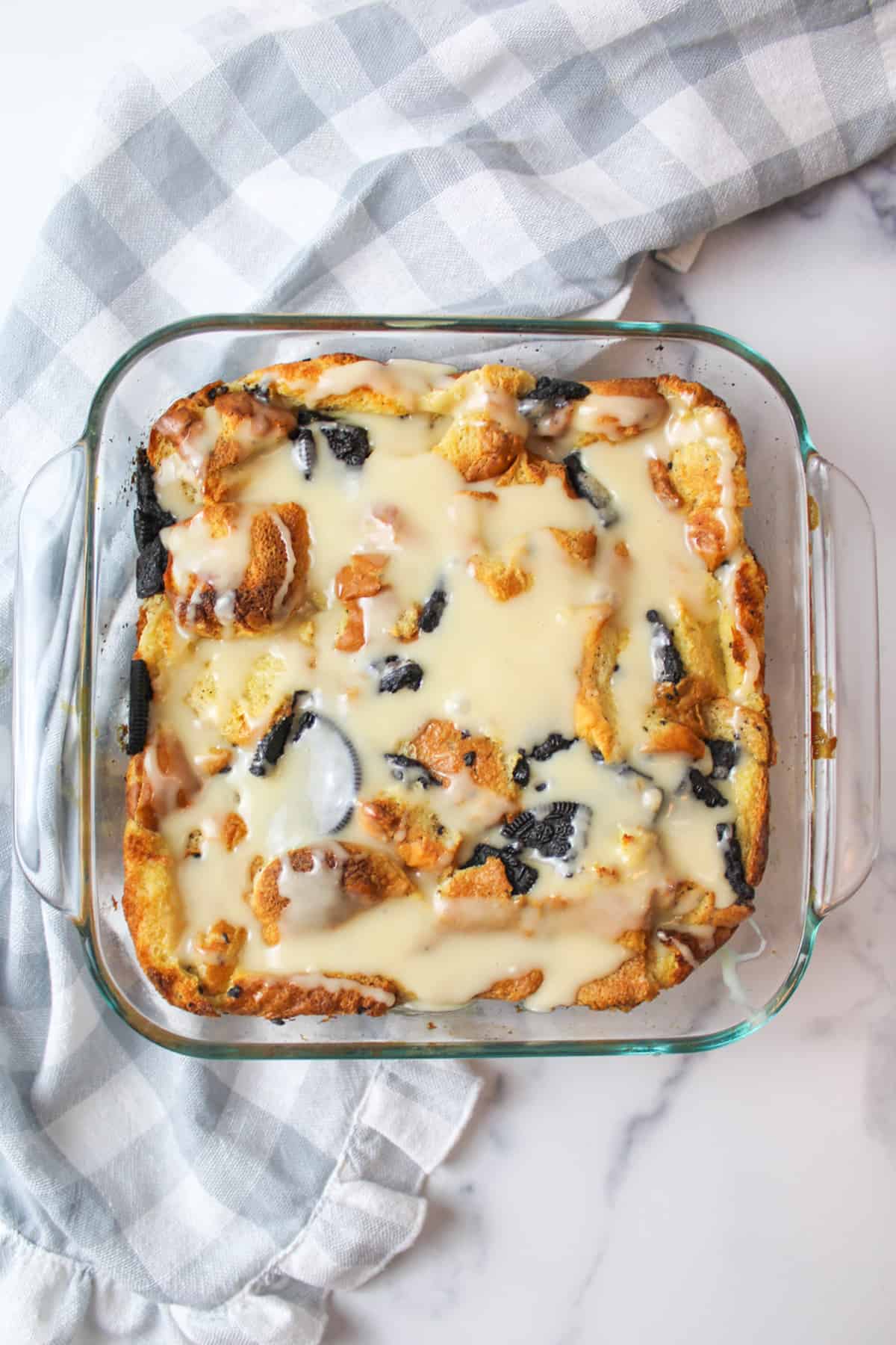 aerial view of icing topped oreo bread pudding in baking dish