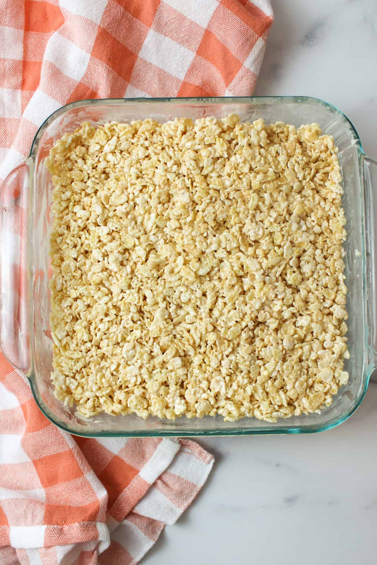 Rice Krispies with Marshmallow Fluff pressed into a buttered 8x8 baking dish.