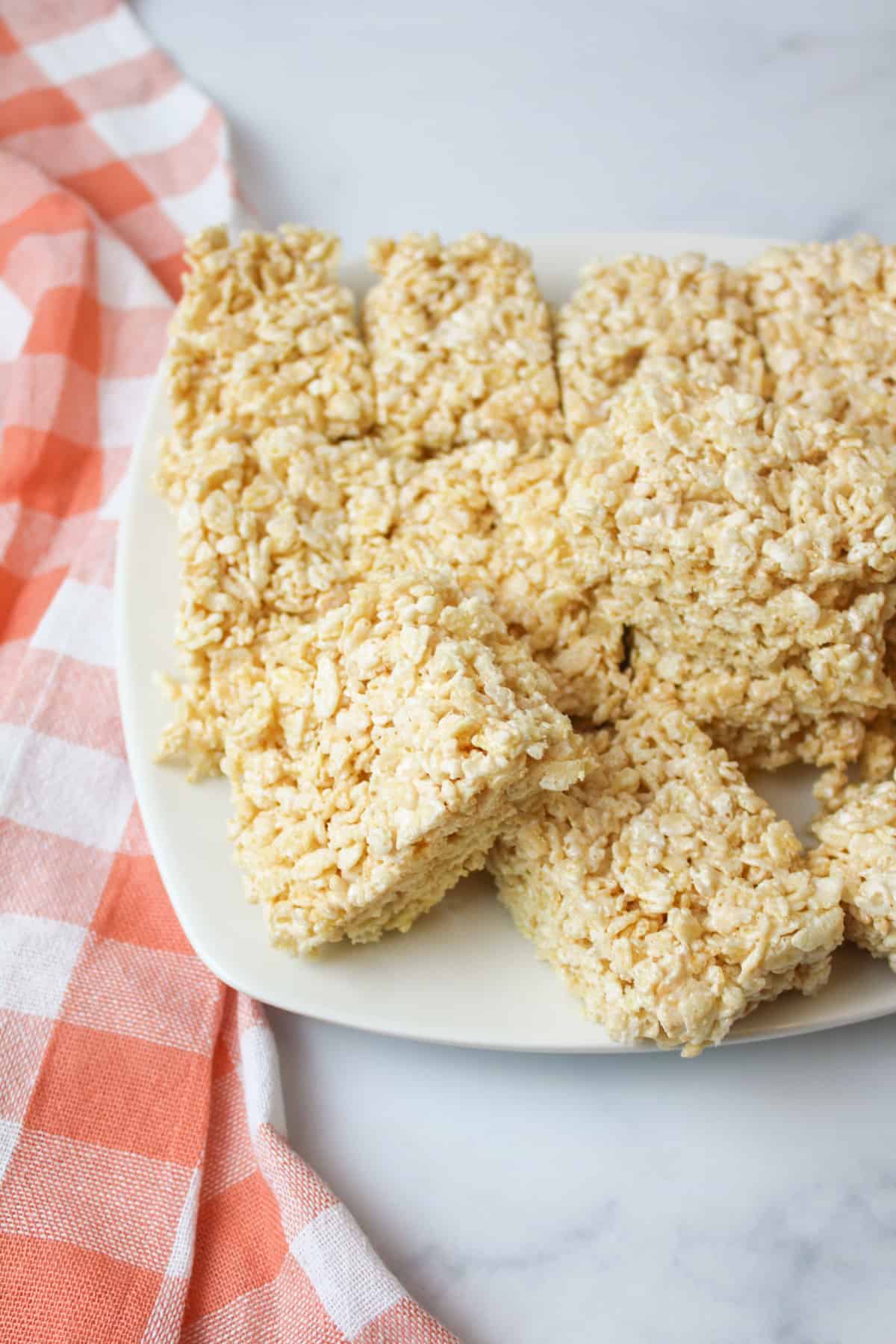 Rice Krispies with Marshmallow Fluff on a plate next to a pink and white towel.