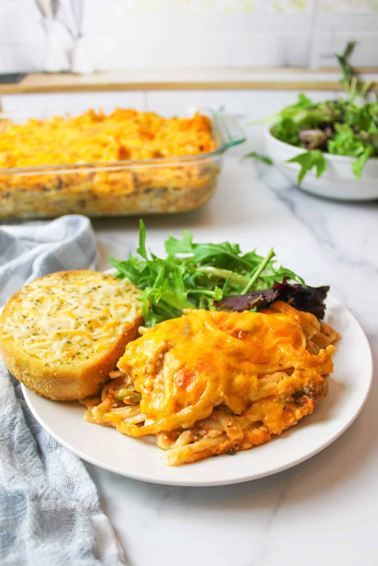 a serving of Southern spaghetti bake on a plate with side dishes.