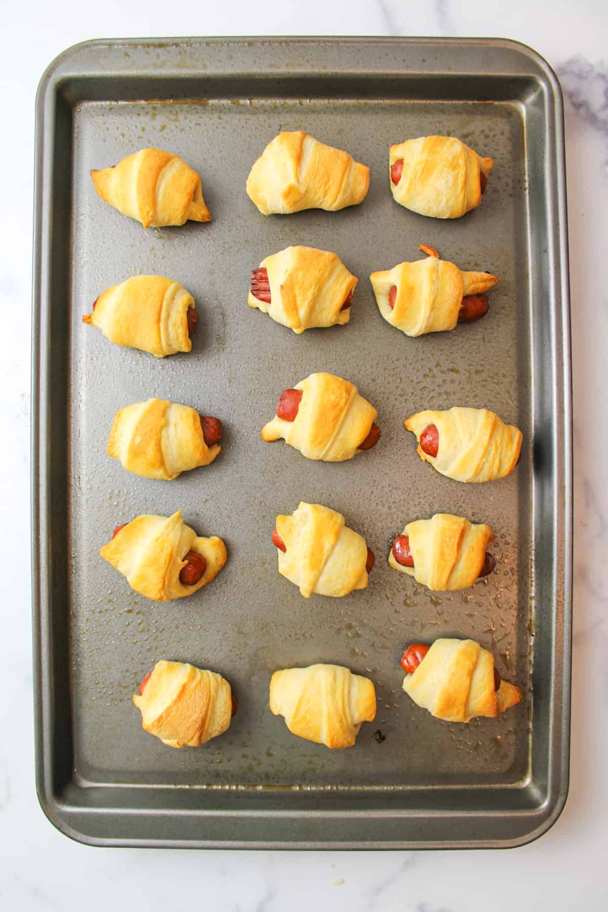 baked mini pigs in a blanket on a baking sheet