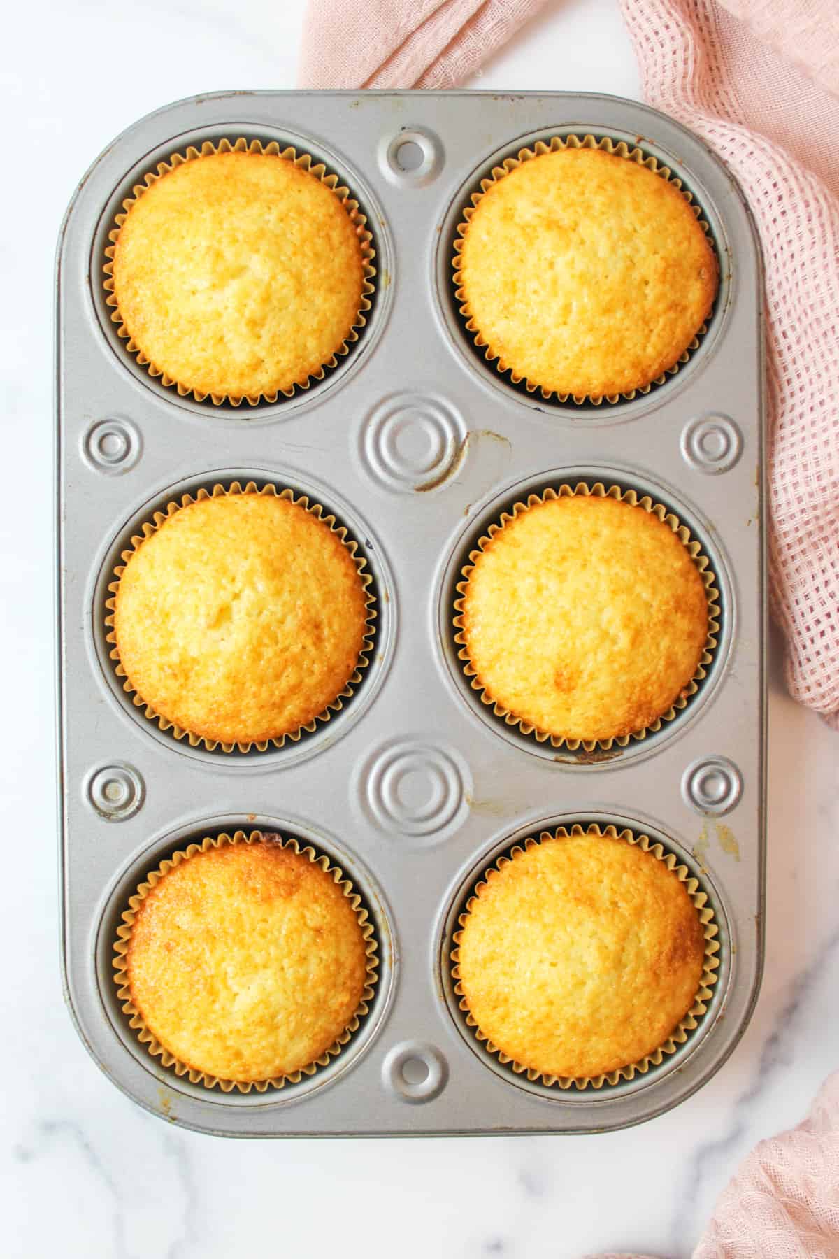 6 baked vanilla muffins in a pan