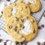 chocolate chip marshmallow cookies on a wire rack with mini marshmallows and chocolate chips scattered around.