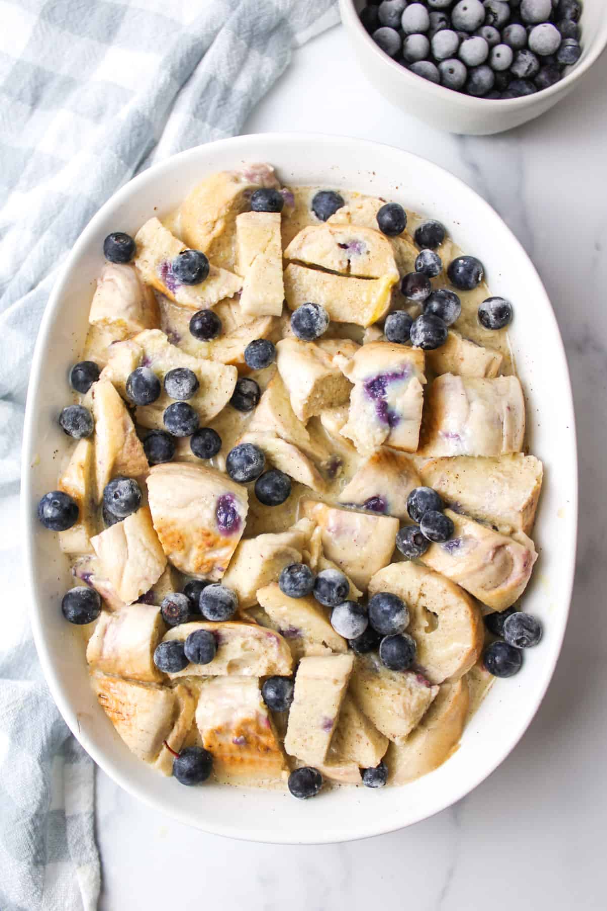 blueberry topped bread and egg mixture in a casserole dish