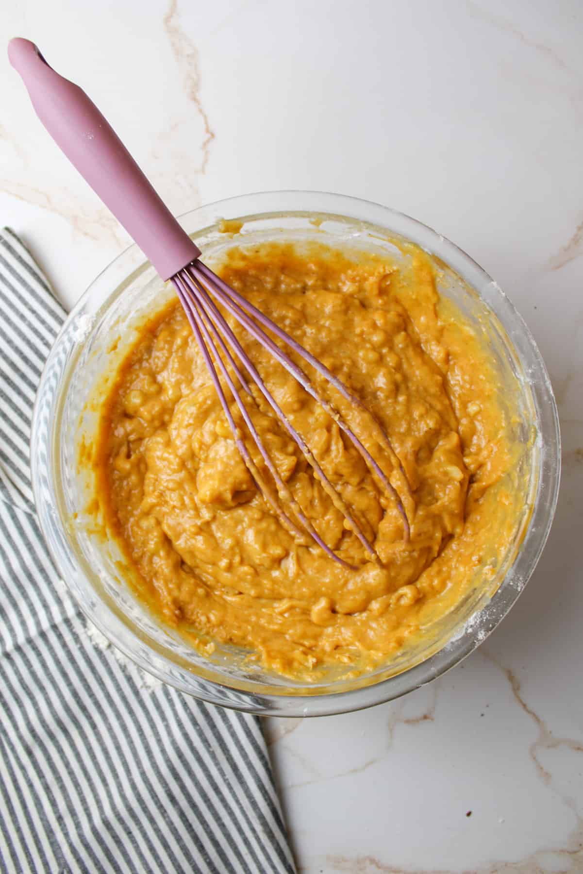 pumpkin banana bread batter in a bowl with a whisk