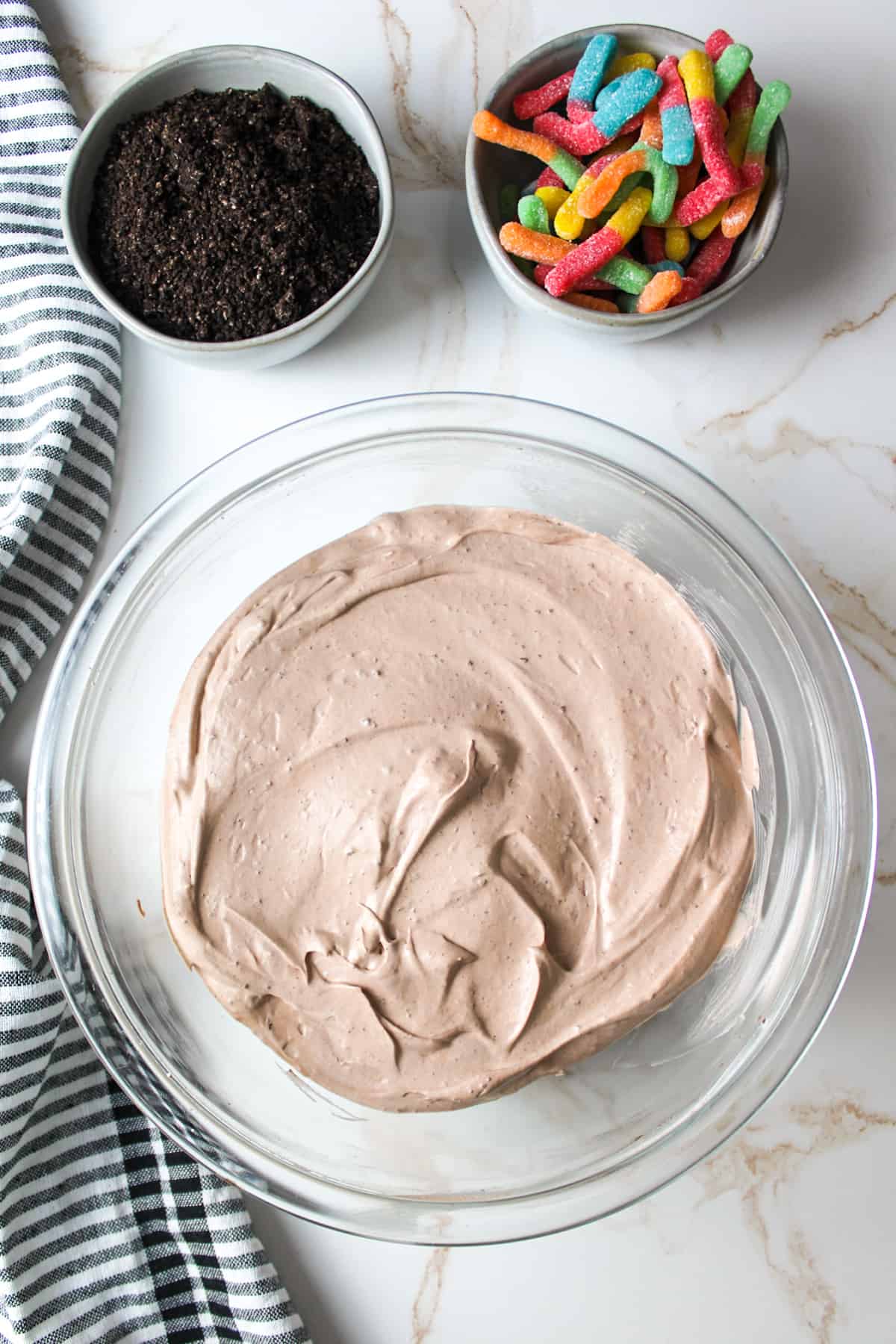 chocolate mousse in a large bowl and worms in bowls to the side