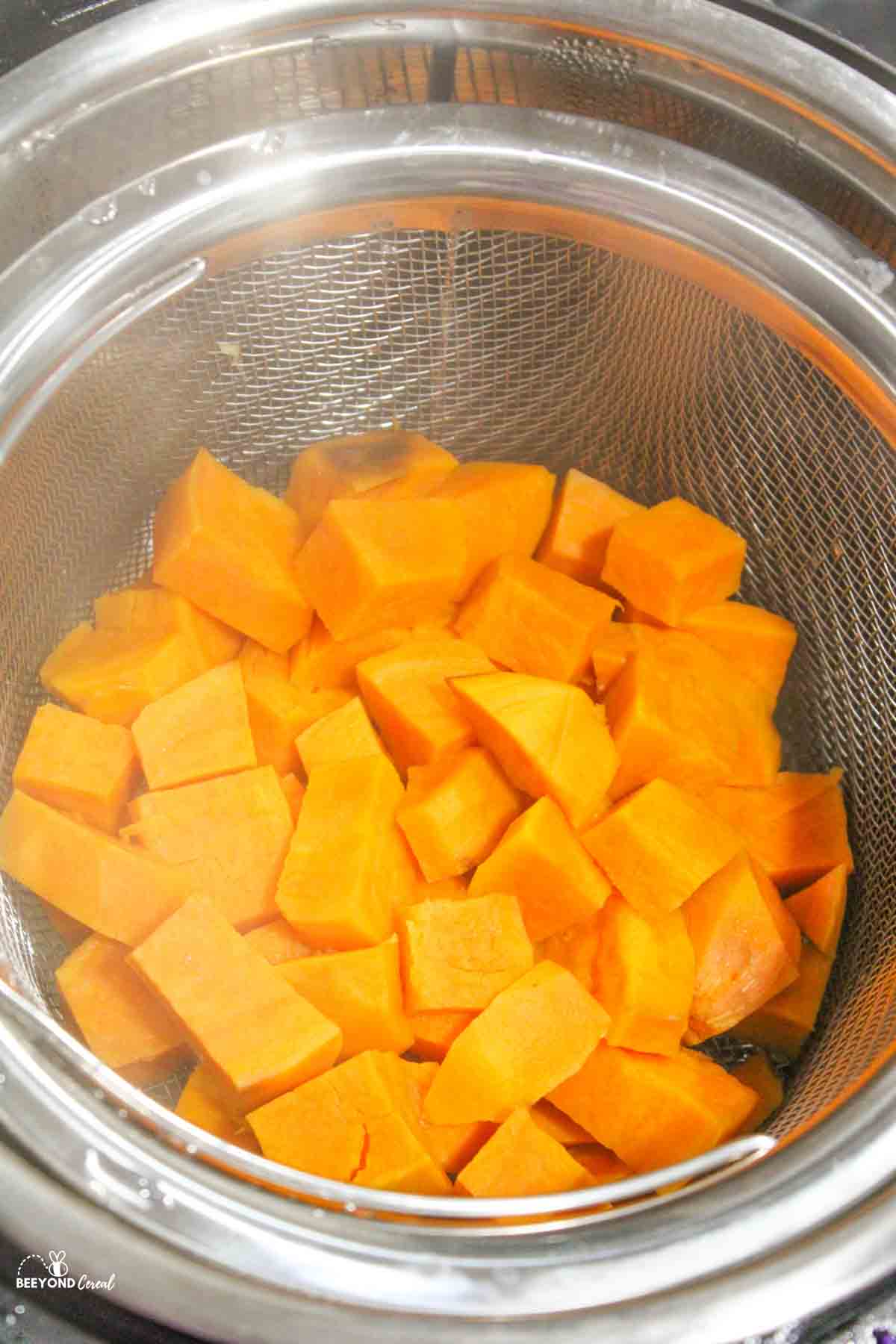 cubed sweet potatoes in a steamer basket in an instant pot