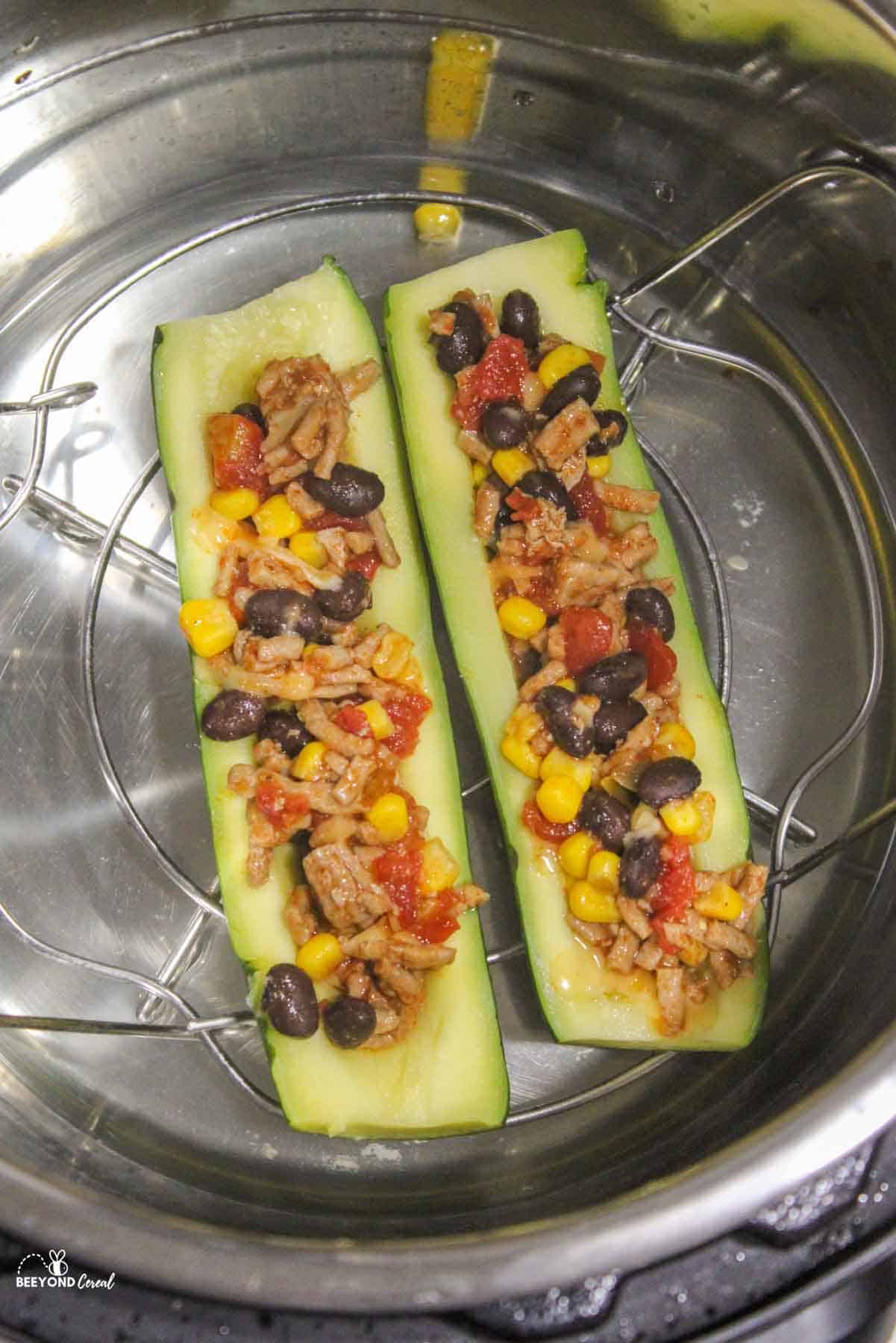 two zucchini boat halveson a trivet inside of an instant pot