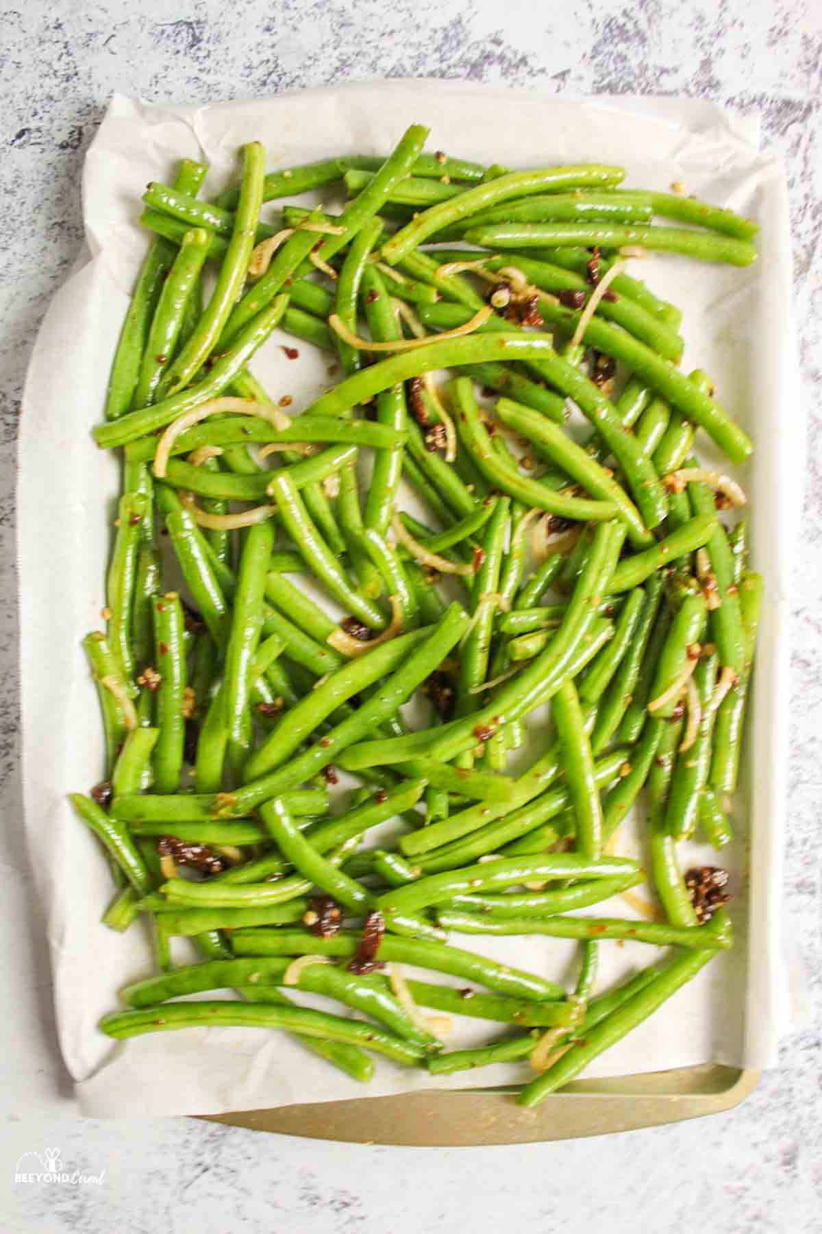 italian green beans unbaked on a parchment paper lined baking sheet