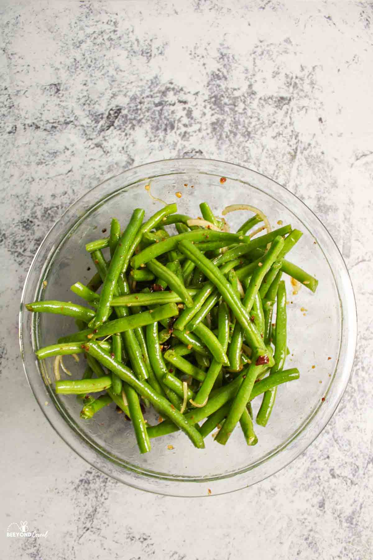 green beans added to mixing bowl filled with italian flavored ingredients
