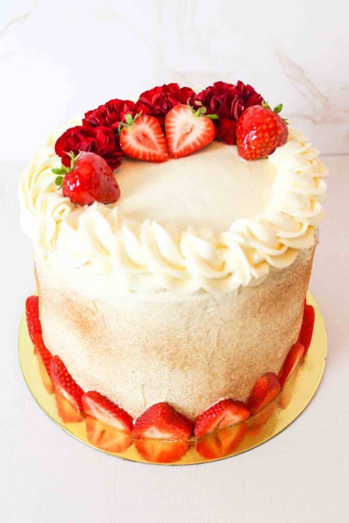 fully decorated tres leches layer cake on a gold cake plate