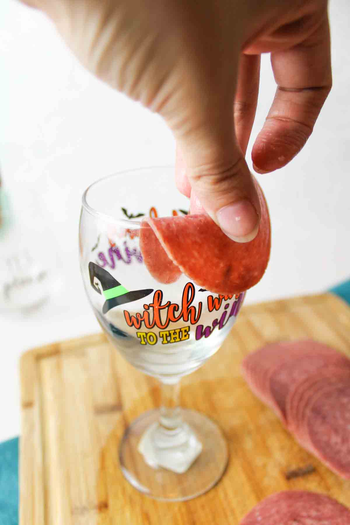 a slice of deli meat folded over a wine glass