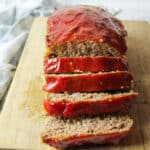sliced loaf of ritz cracker meatloaf on a wooden cutting board
