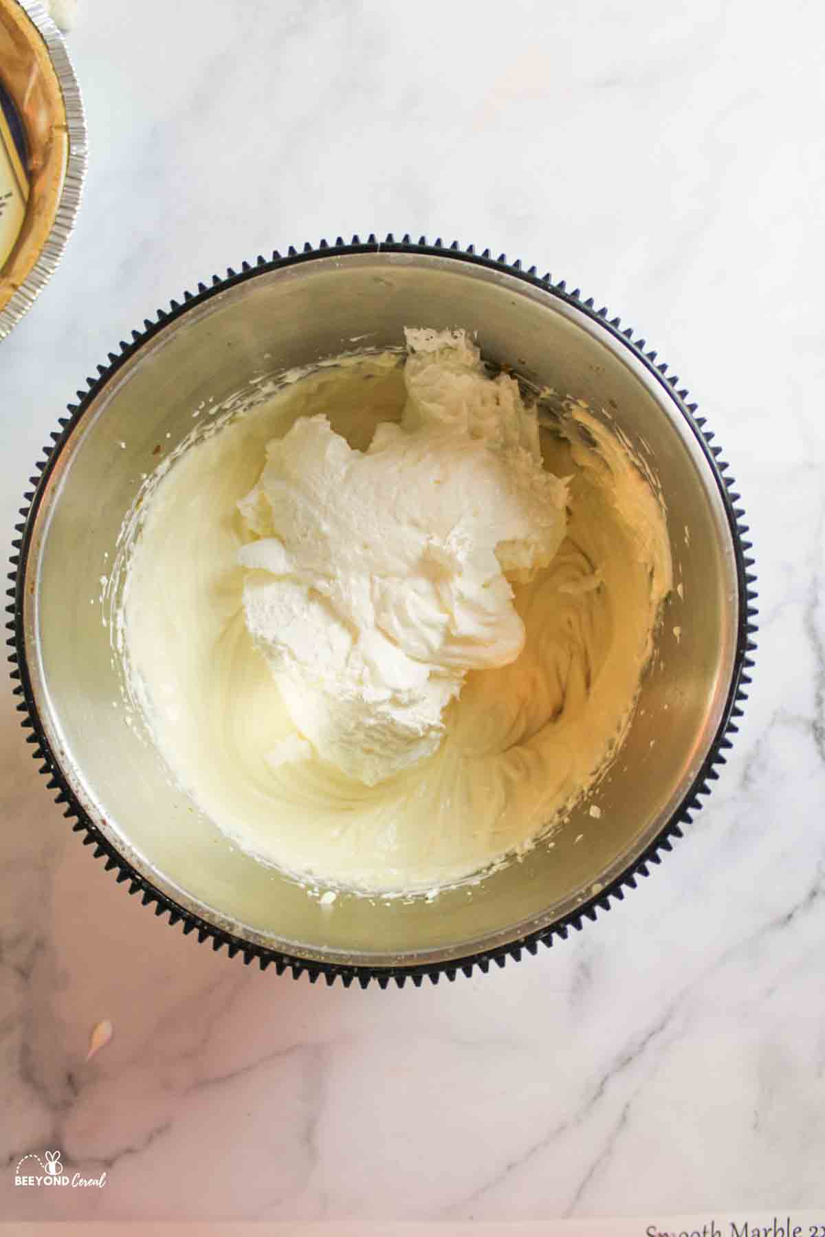 cool whip added to cheesecake mixture in mixing bowl