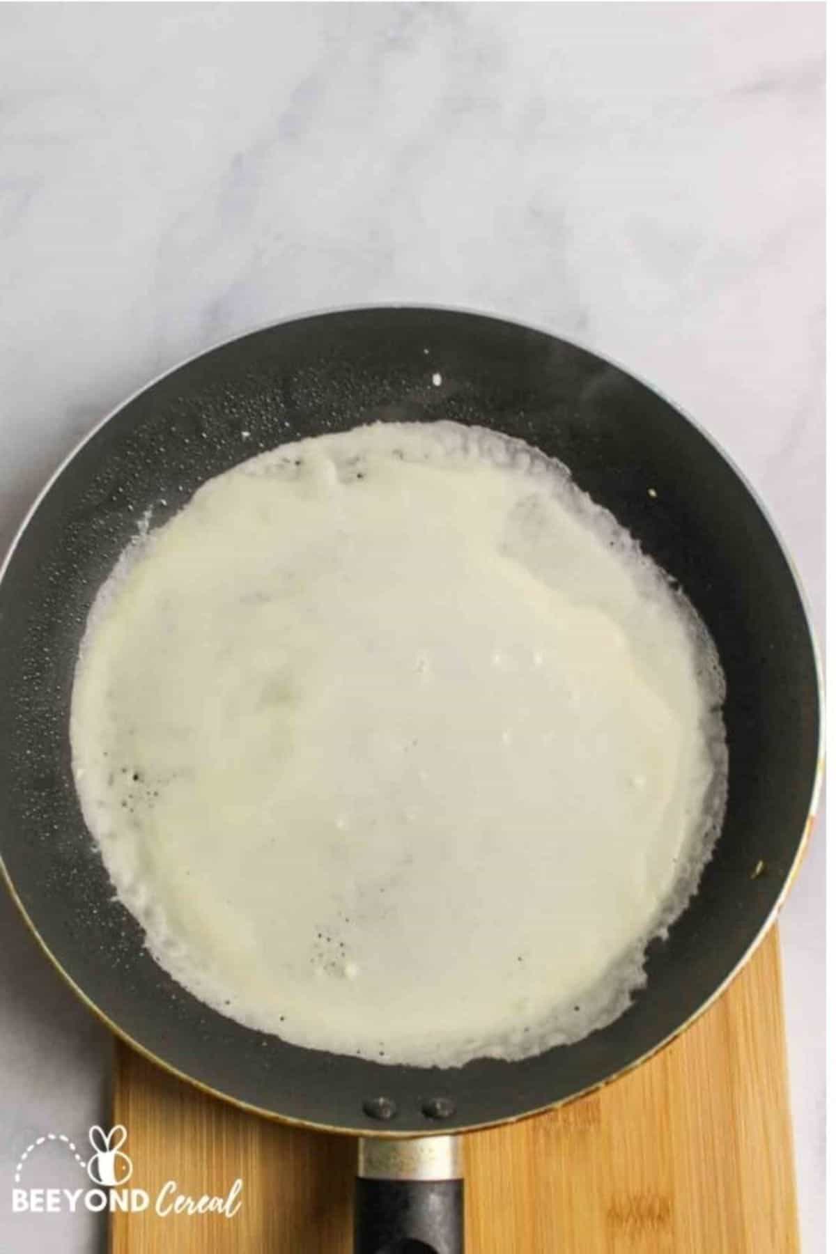 pancake crepe batter in a hot skillet.