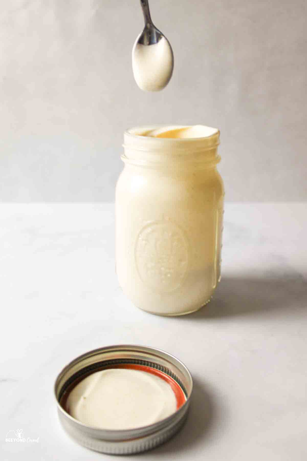 a spoon held above the mason jar ice cream mixture to show it not dripping.