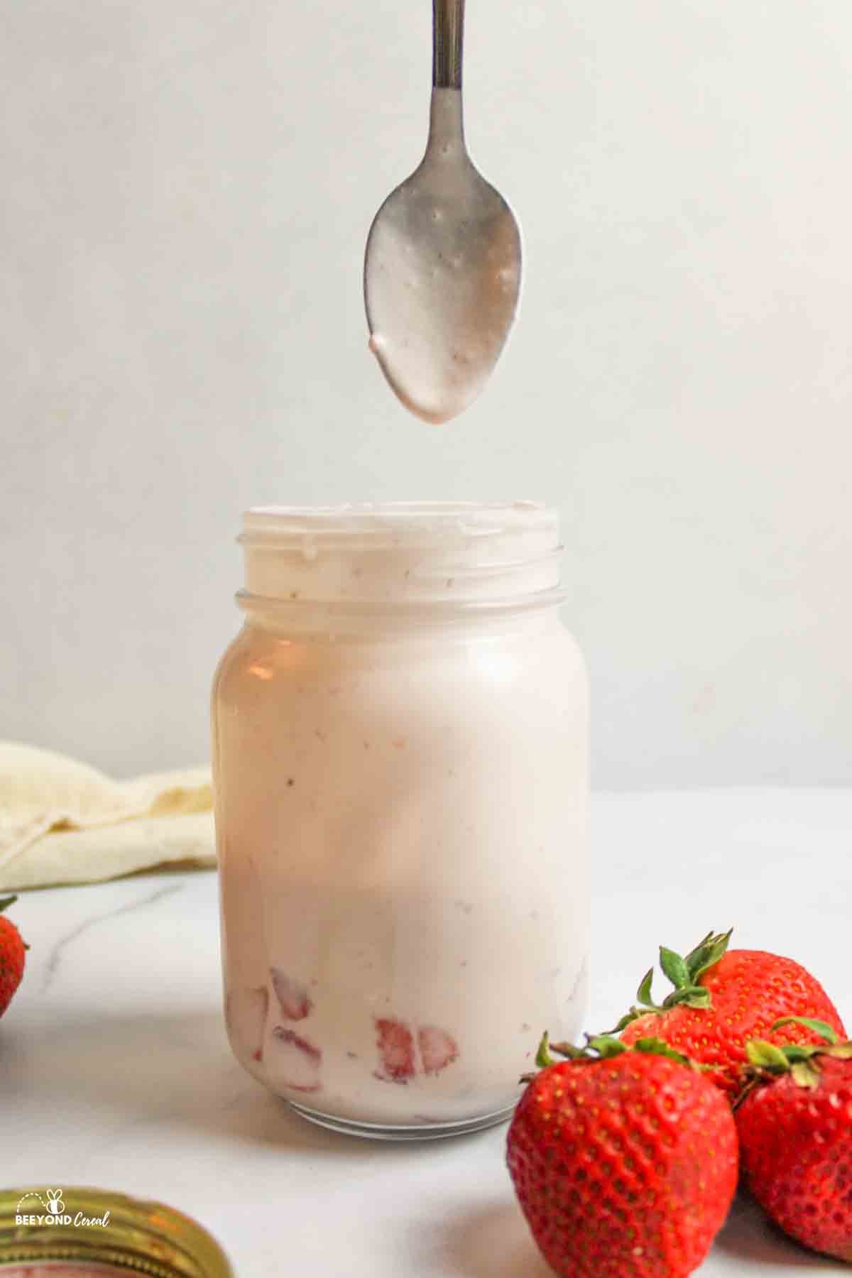 thick mixture on a spoon held above opened mason jar