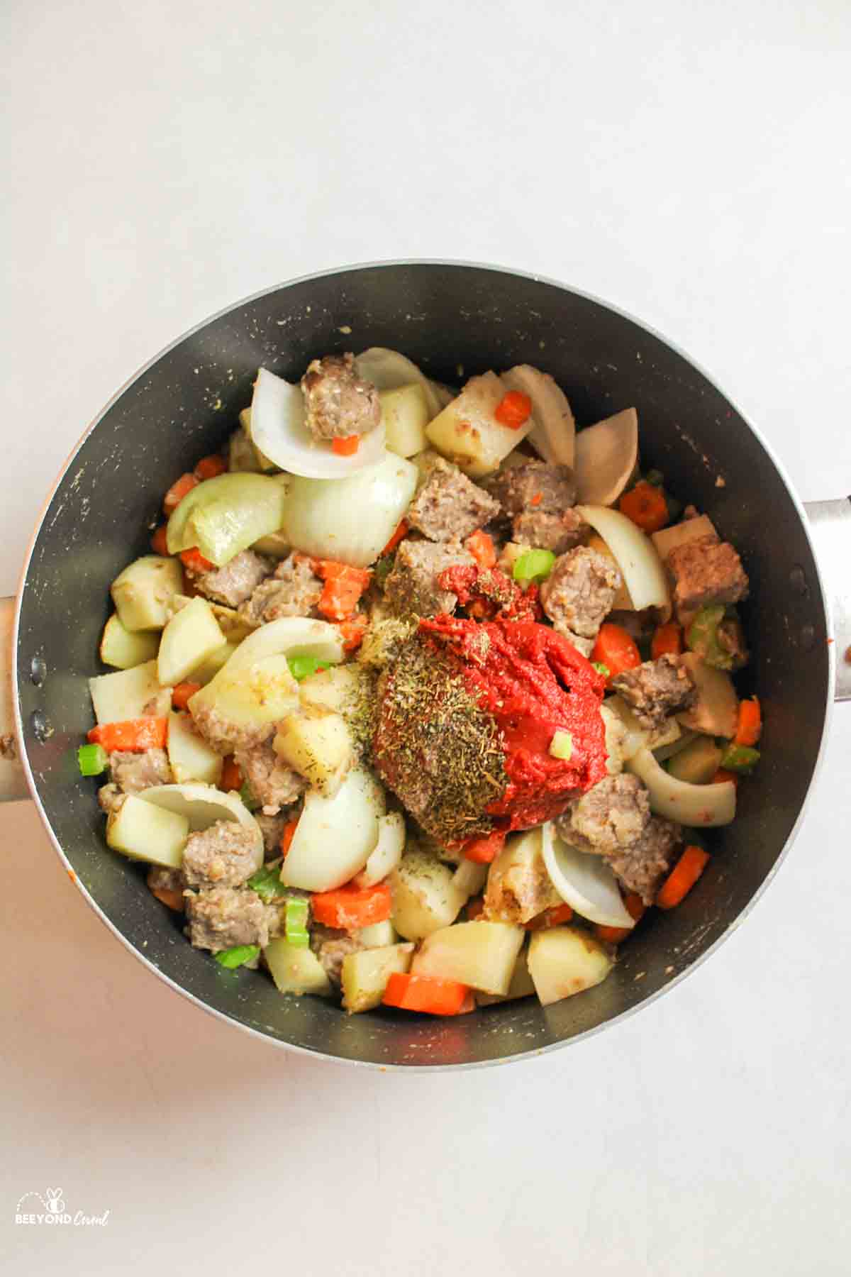 tomato paste and seasonings added to large pot with cooked veggies and stew meat