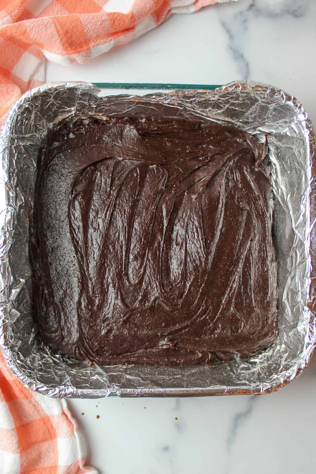 brownie batter in a foil lined baking dish.