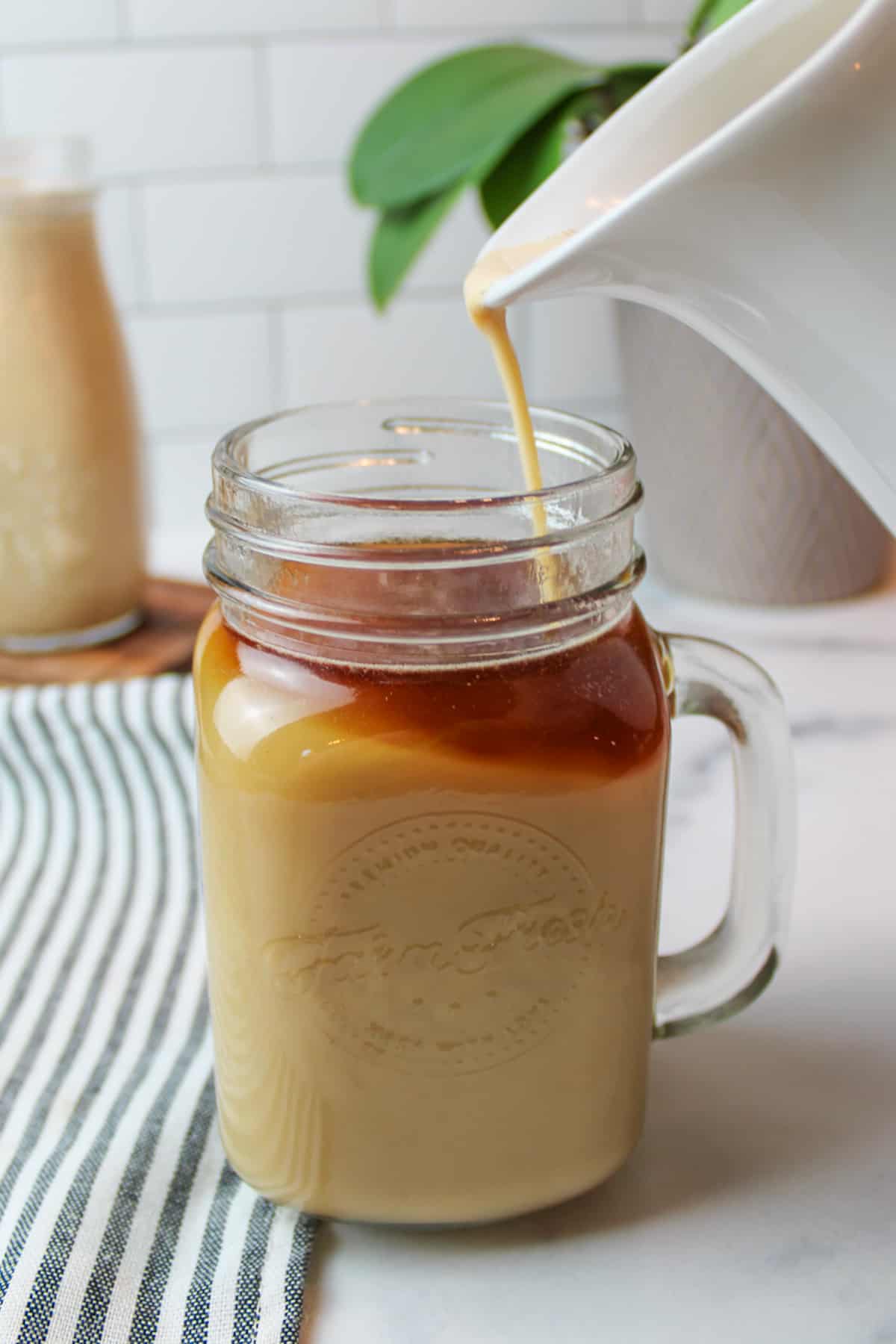 pumpkin creamer pouring into a glass of coffee