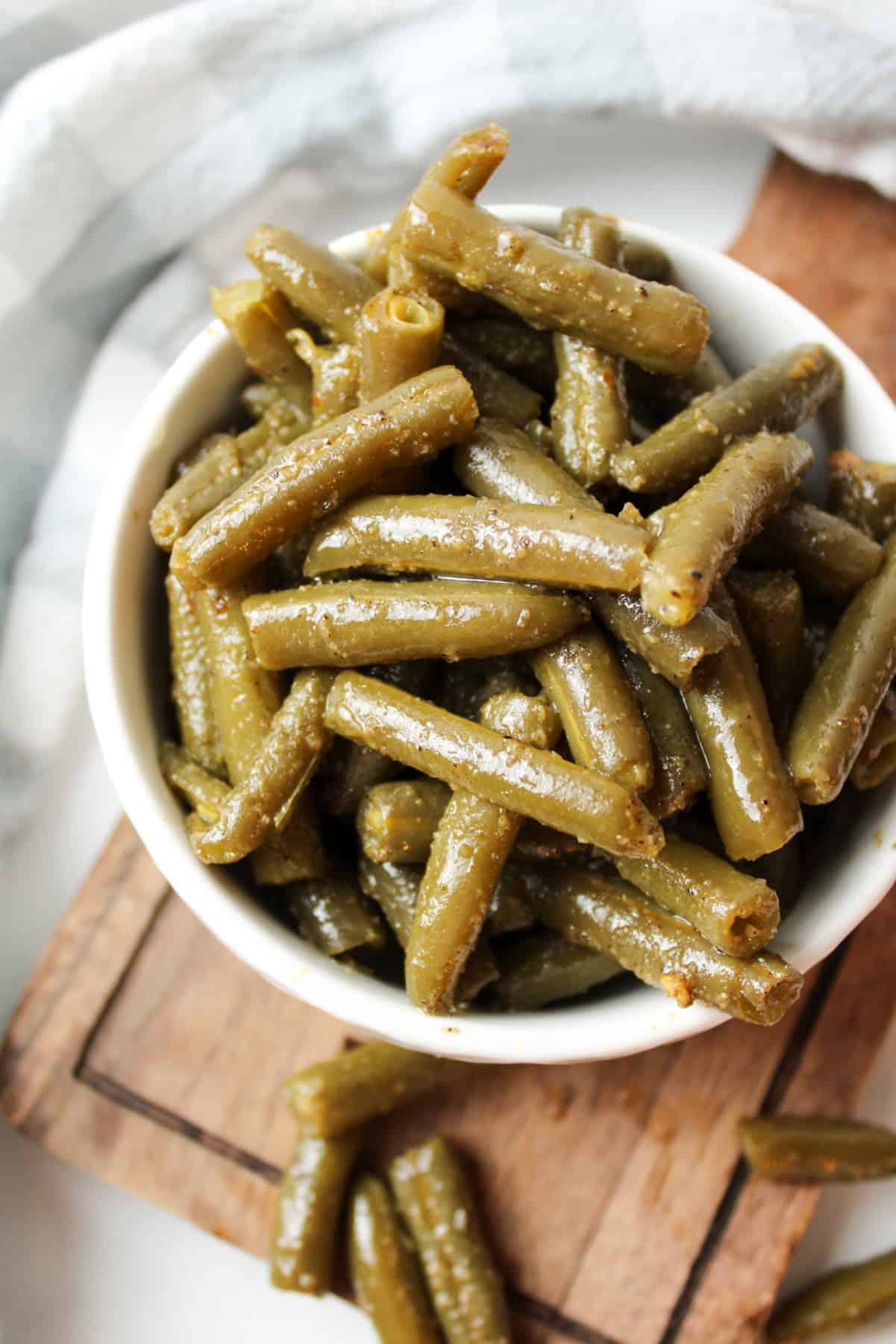 a white bowl filled with cooked canned green beans.