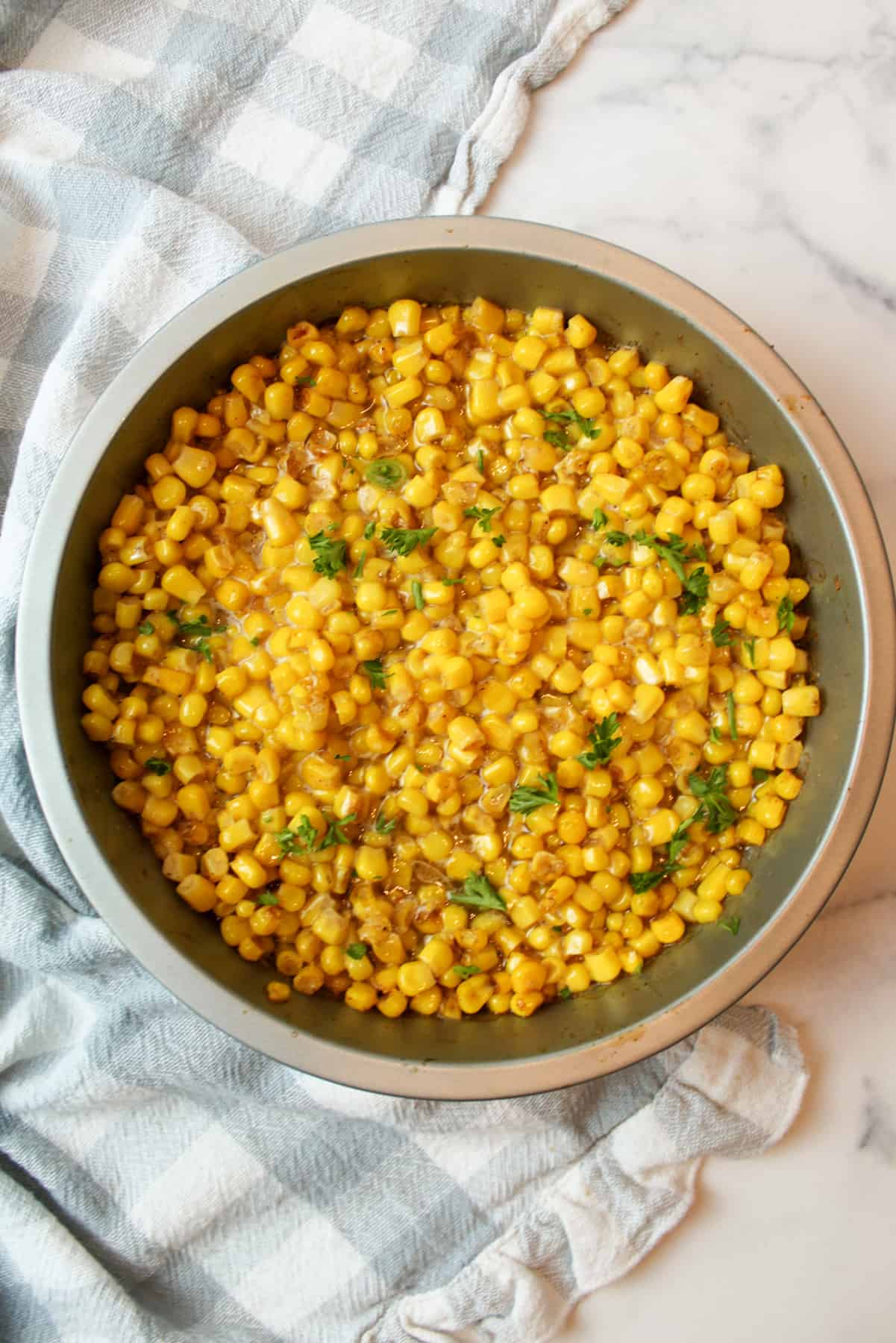 air fried corn in a cake pan topped with fresh parsley