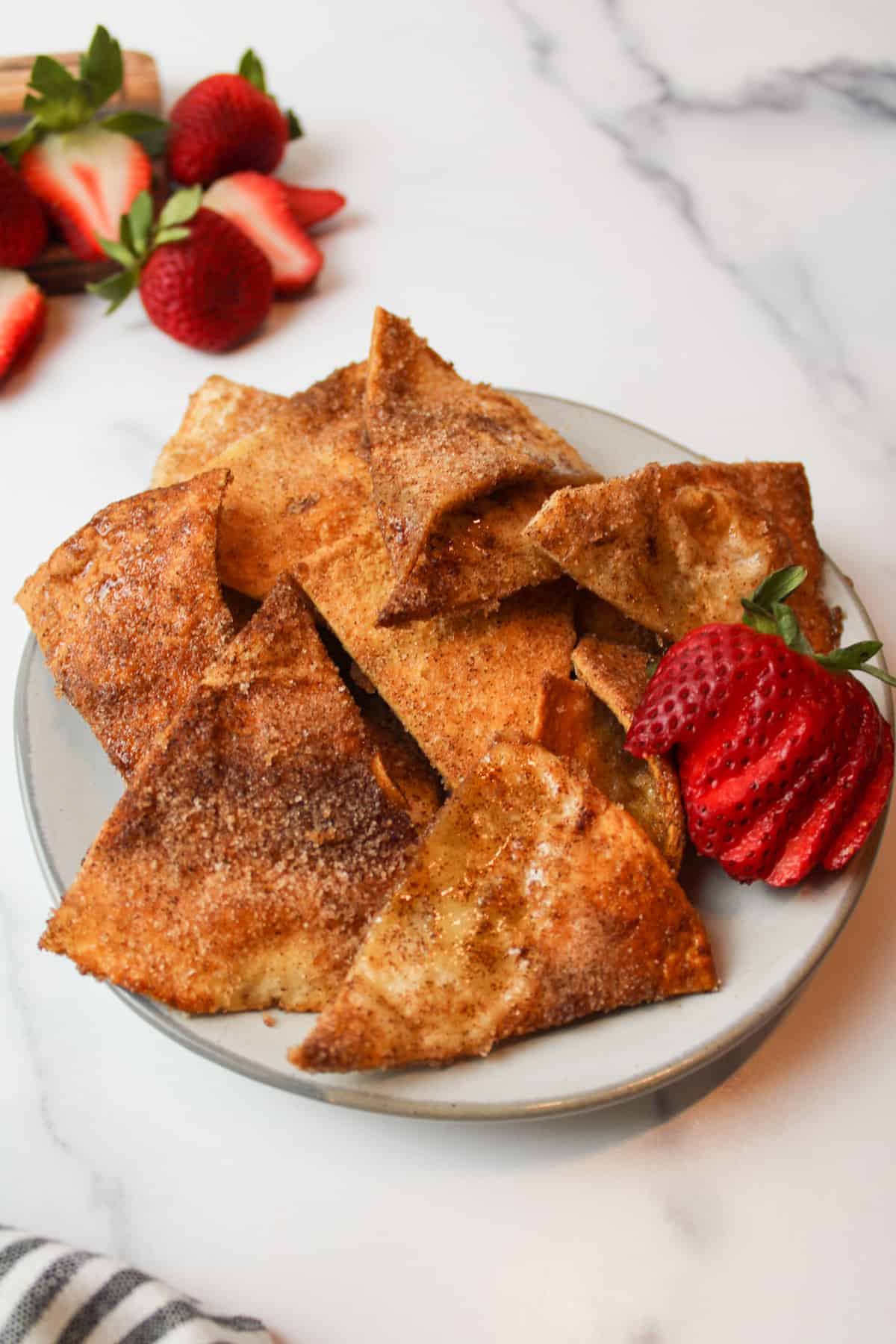 fresh strawberries and cinnamon sugar tortilla chips on a plate.