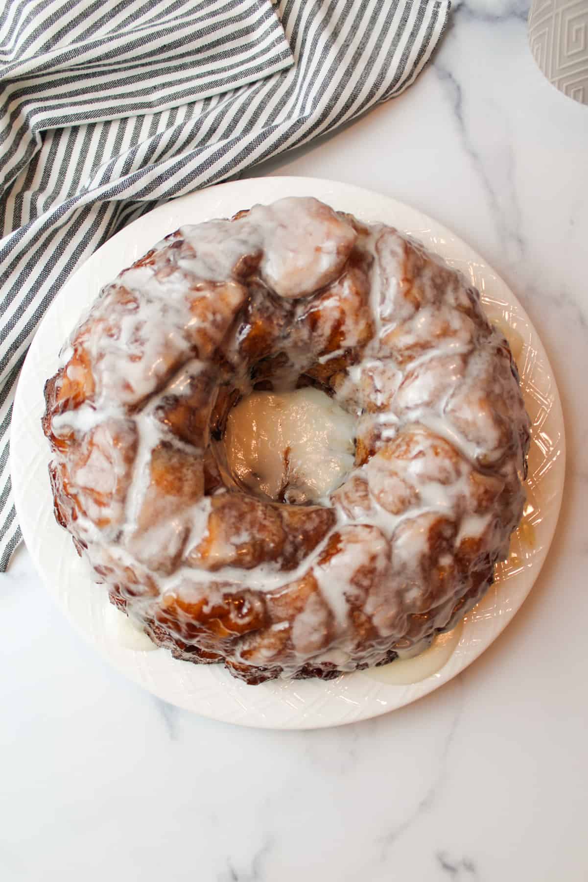 aerial view of icing covered monkey bread bundt cake on a plate