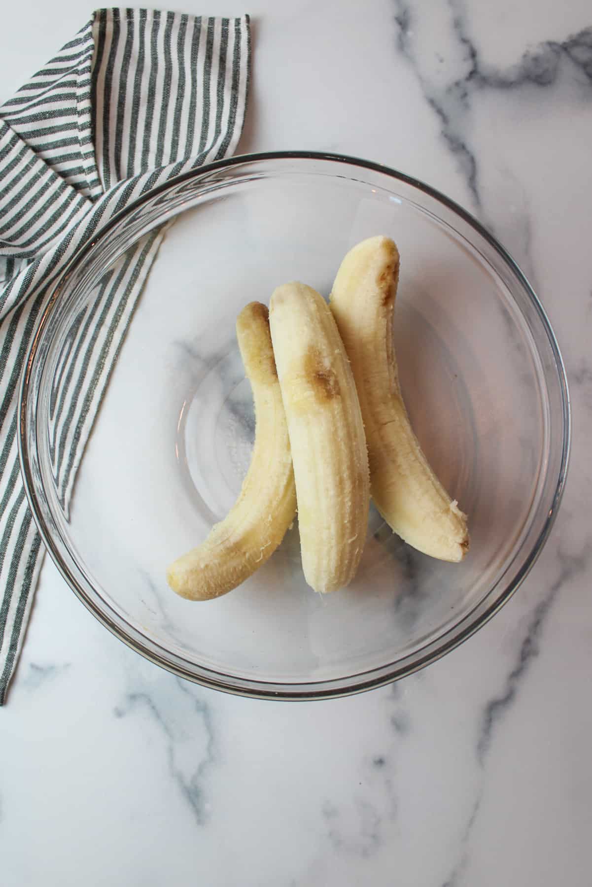 three ripe bananas in a mixing bowl.