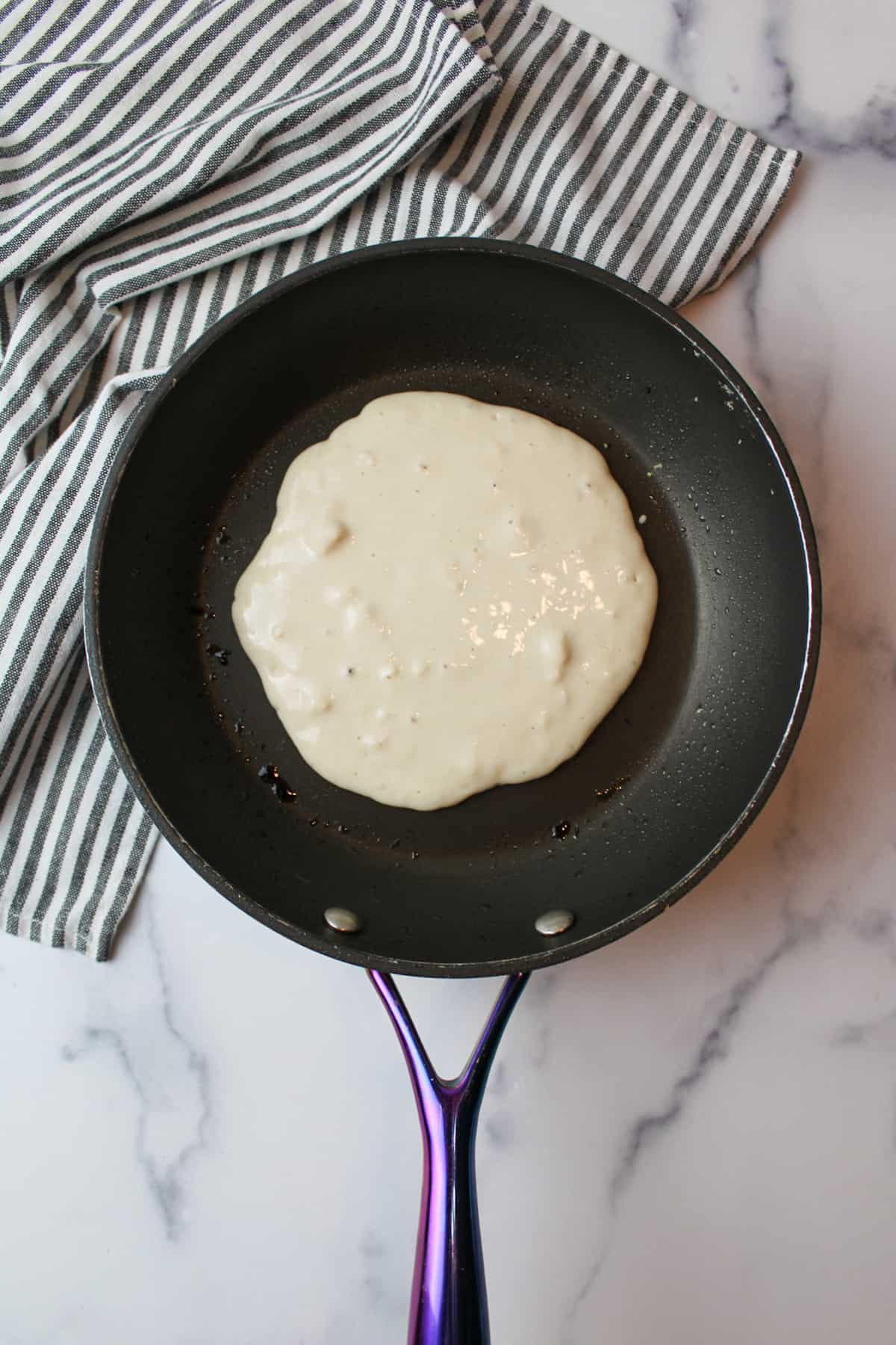 raw pancake batter in a skillet.