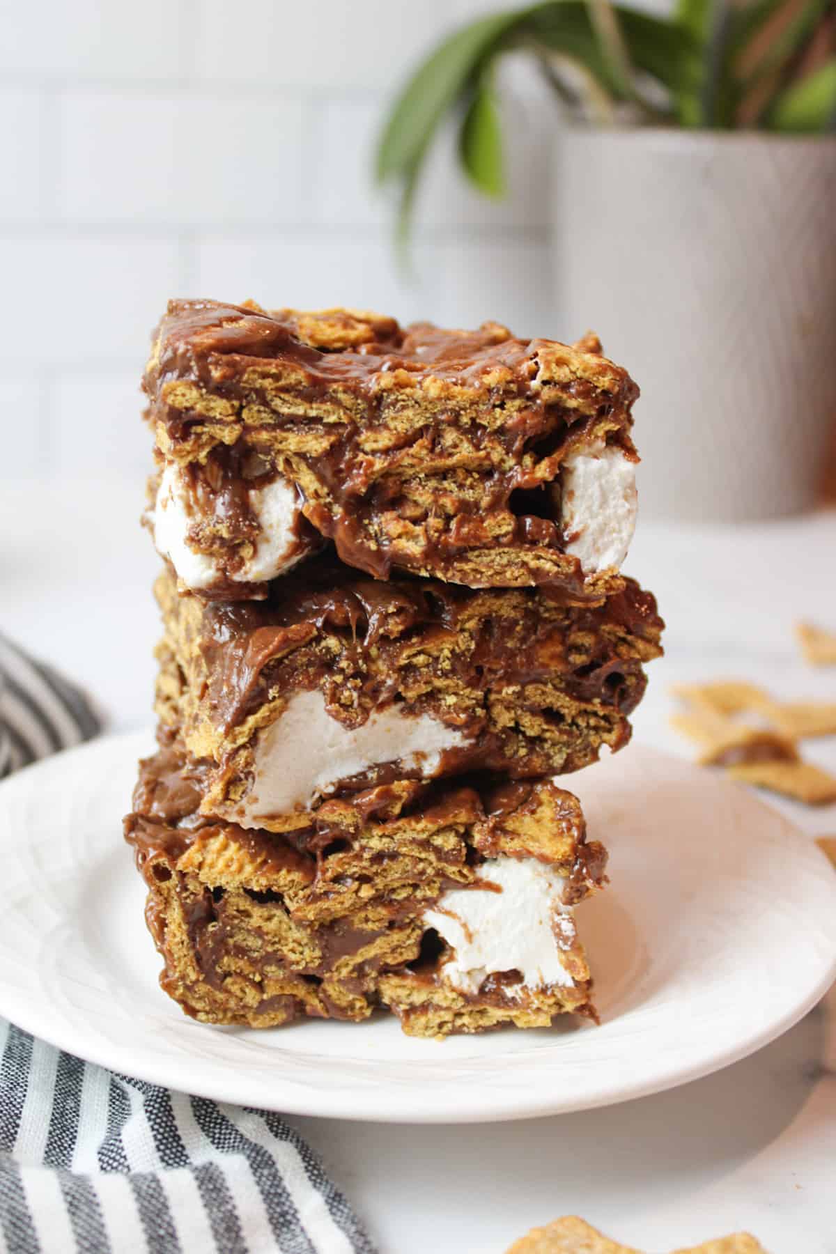 three stacked smore bar squares on a white plate.