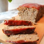 sliced meatloaf on a wooden cutting board.