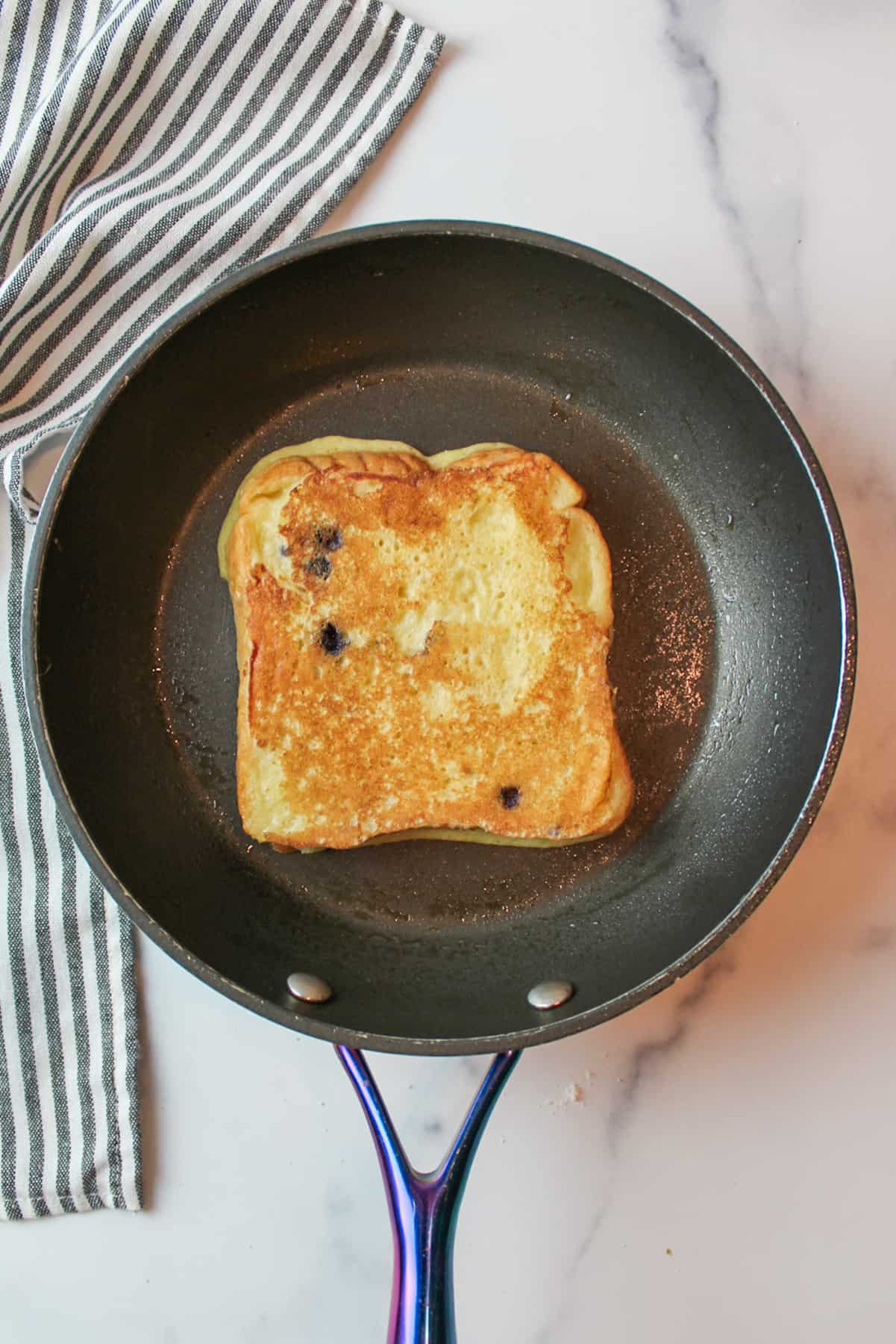 cooked muffin mix french toast in a frying pan.