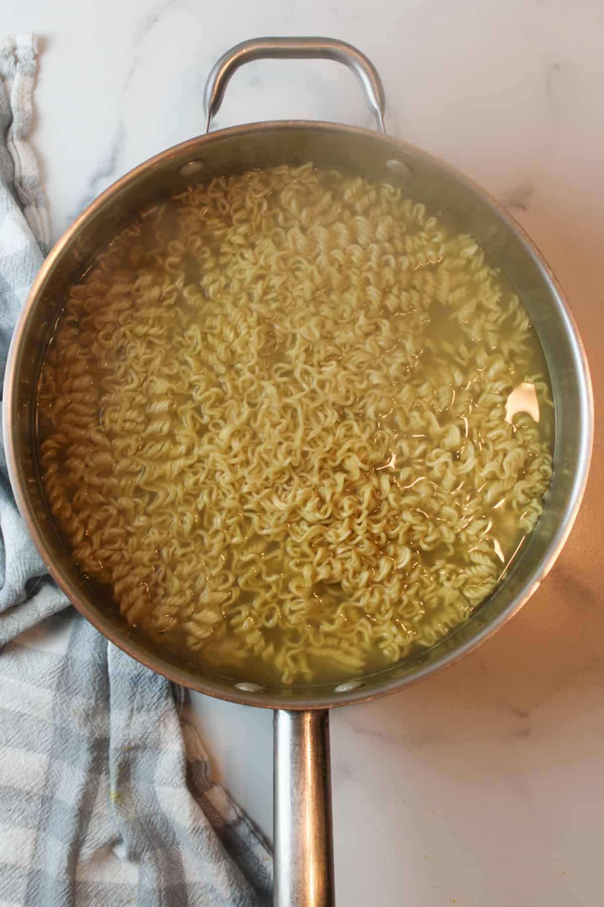 cooked ramen in a large steamy pan.