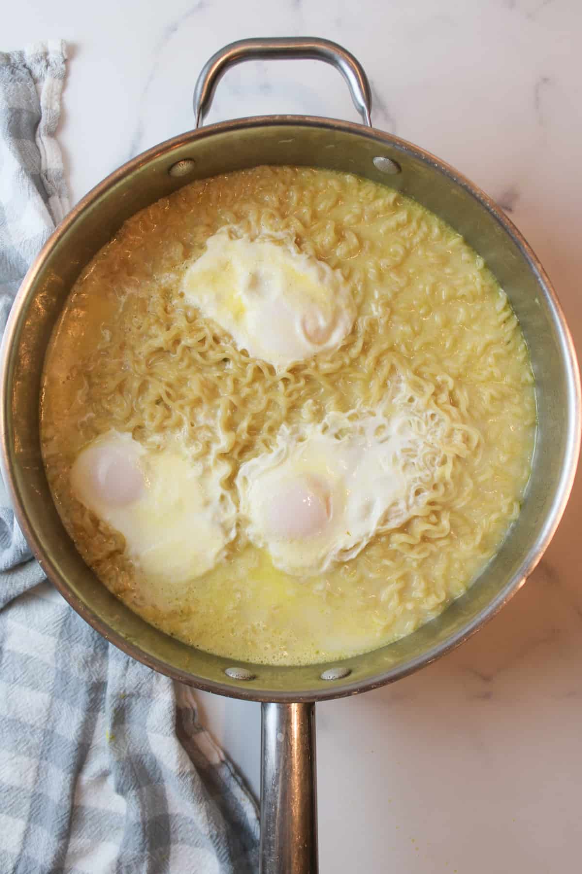 poached eggs on cooked ramen in a large pot