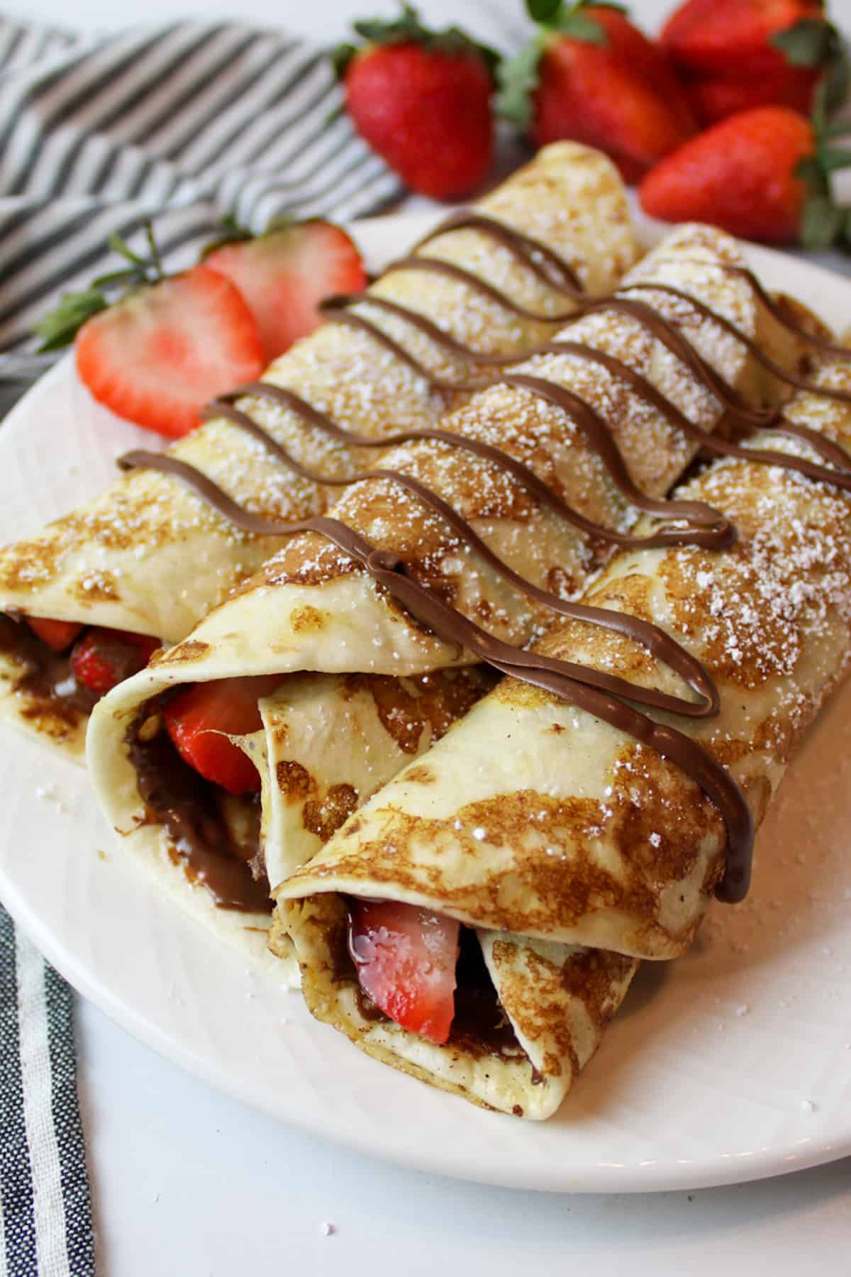 french toast tortillas rolled up with nutella and sliced fresh strawberries.