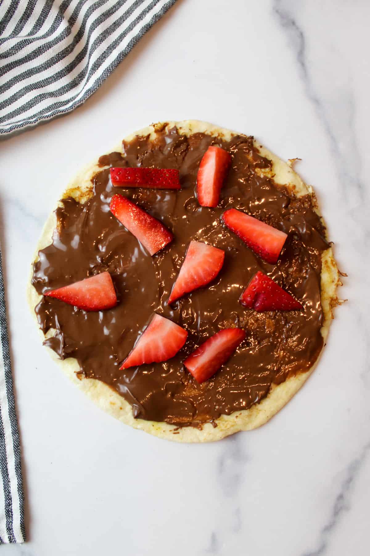 nutella and fresh strawberries on an open faced french toast tortilla