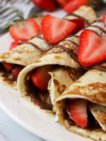 an upclose view of rolled french toast tortillas with nutella and strawberries
