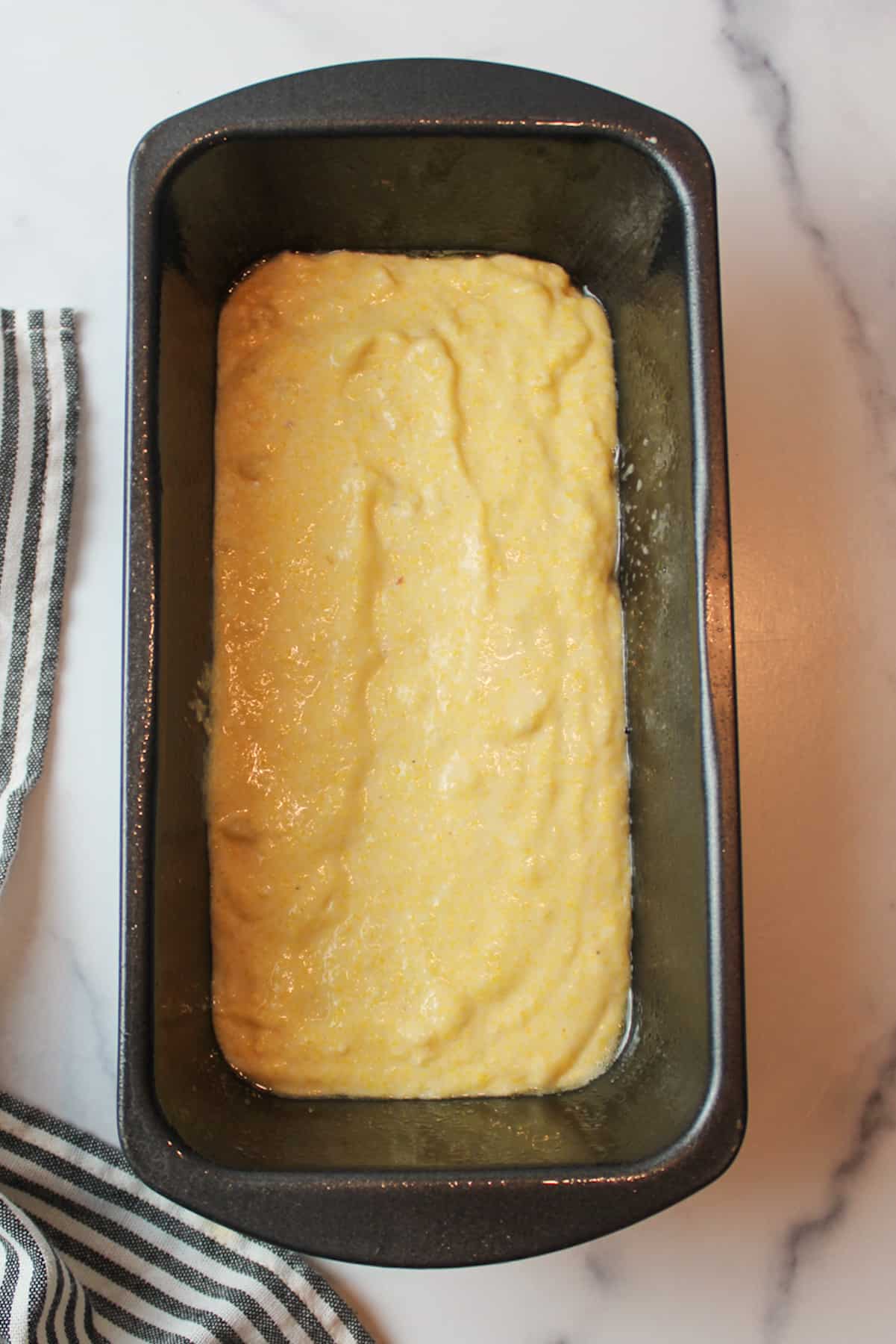 banana cornbread batter in a bread loaf pan.