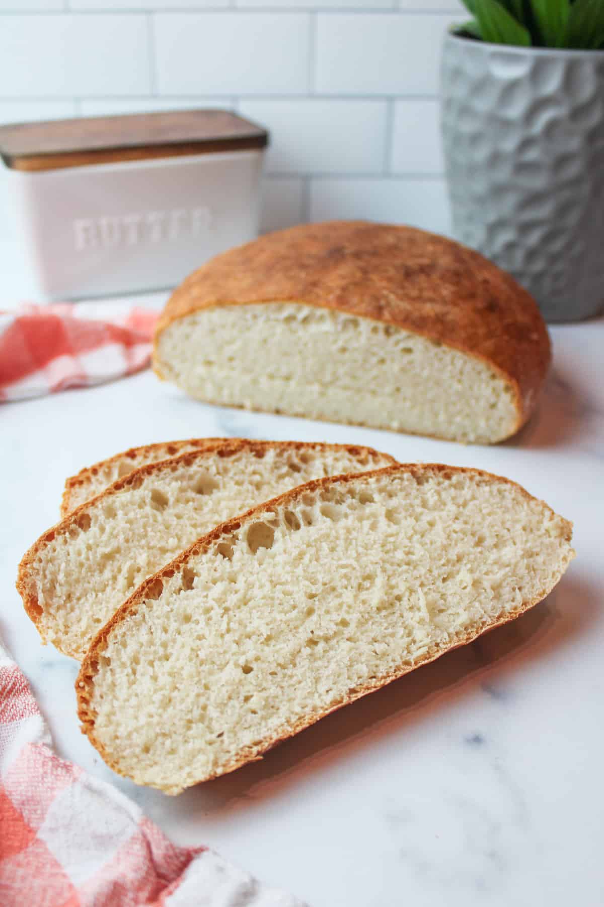 three slices of white bread with a half a loaf in the background.