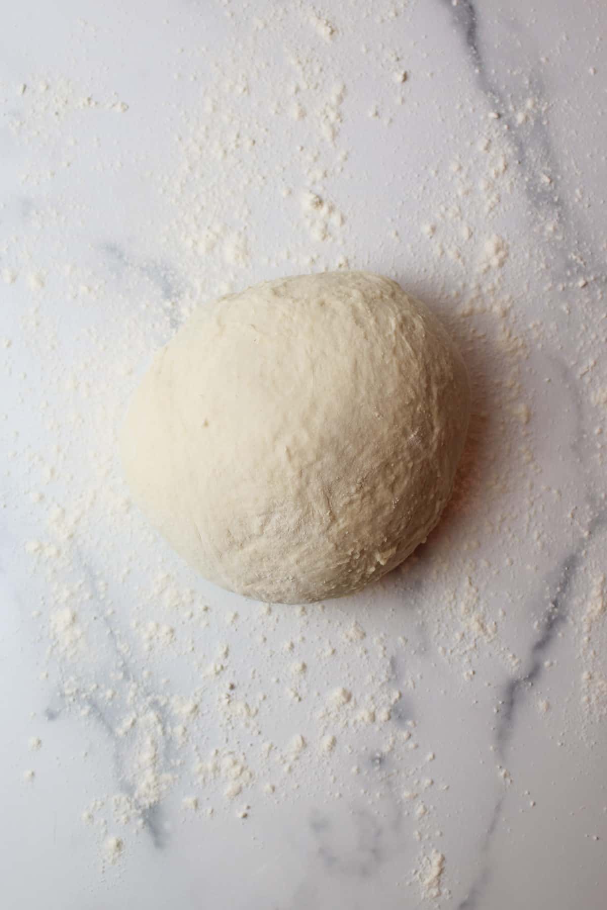 a ball of smooth dough on a floured surface