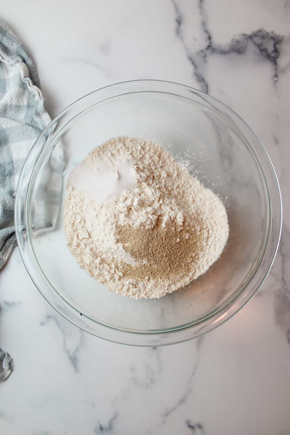 aerial view of yeast salt sugar and flour in a mixing bowl