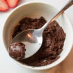 a bowl of fudge with a spoon holding a small bite of it at the tip.