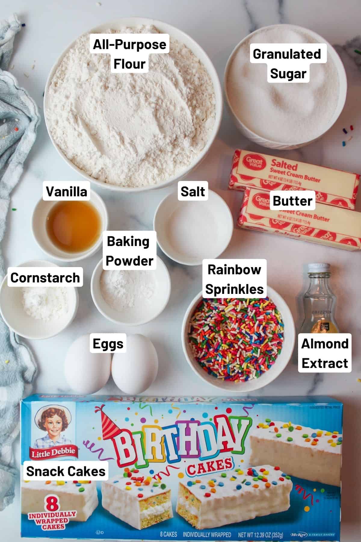 labeled ingredients needed to make birthday cake stuffed cookies.