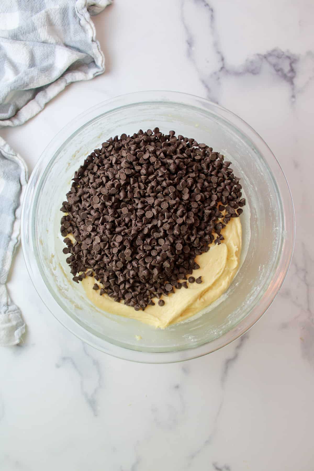 mini chocolate chips on top of cake batter in a mixing bowl
