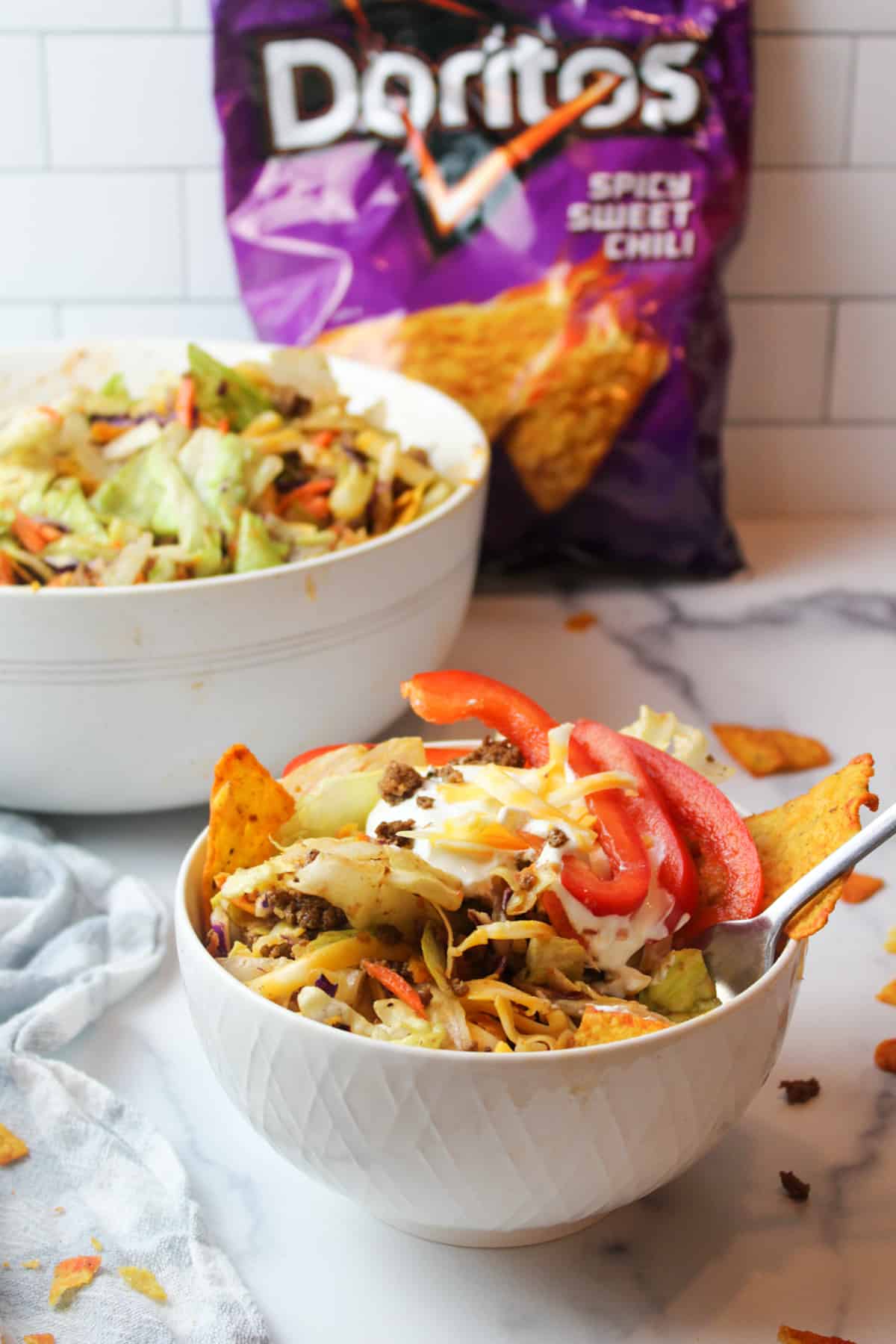 Doritos taco salad in serving bowl, big salad bowl, bag of Doritos.