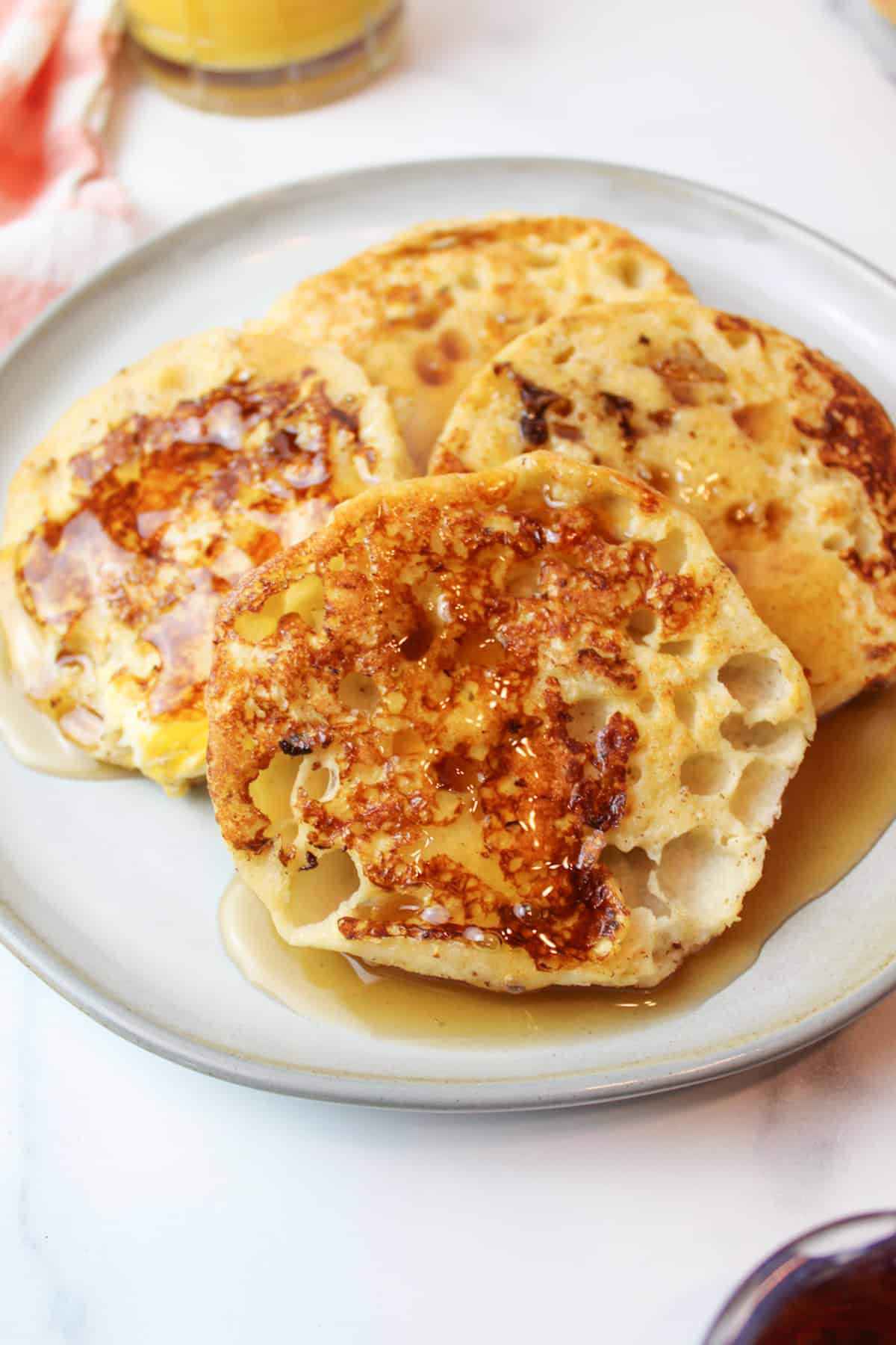 french toast english muffins on a plate with maple syrup on top.