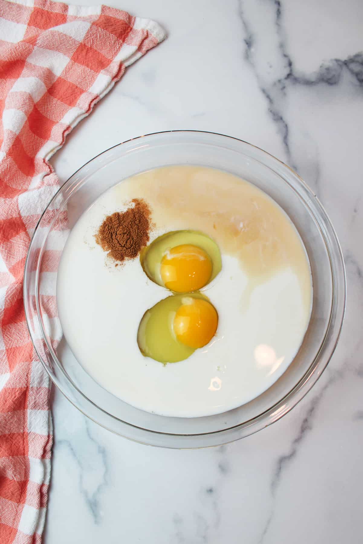 eggs milk cinnamon and vanilla in a pie plate