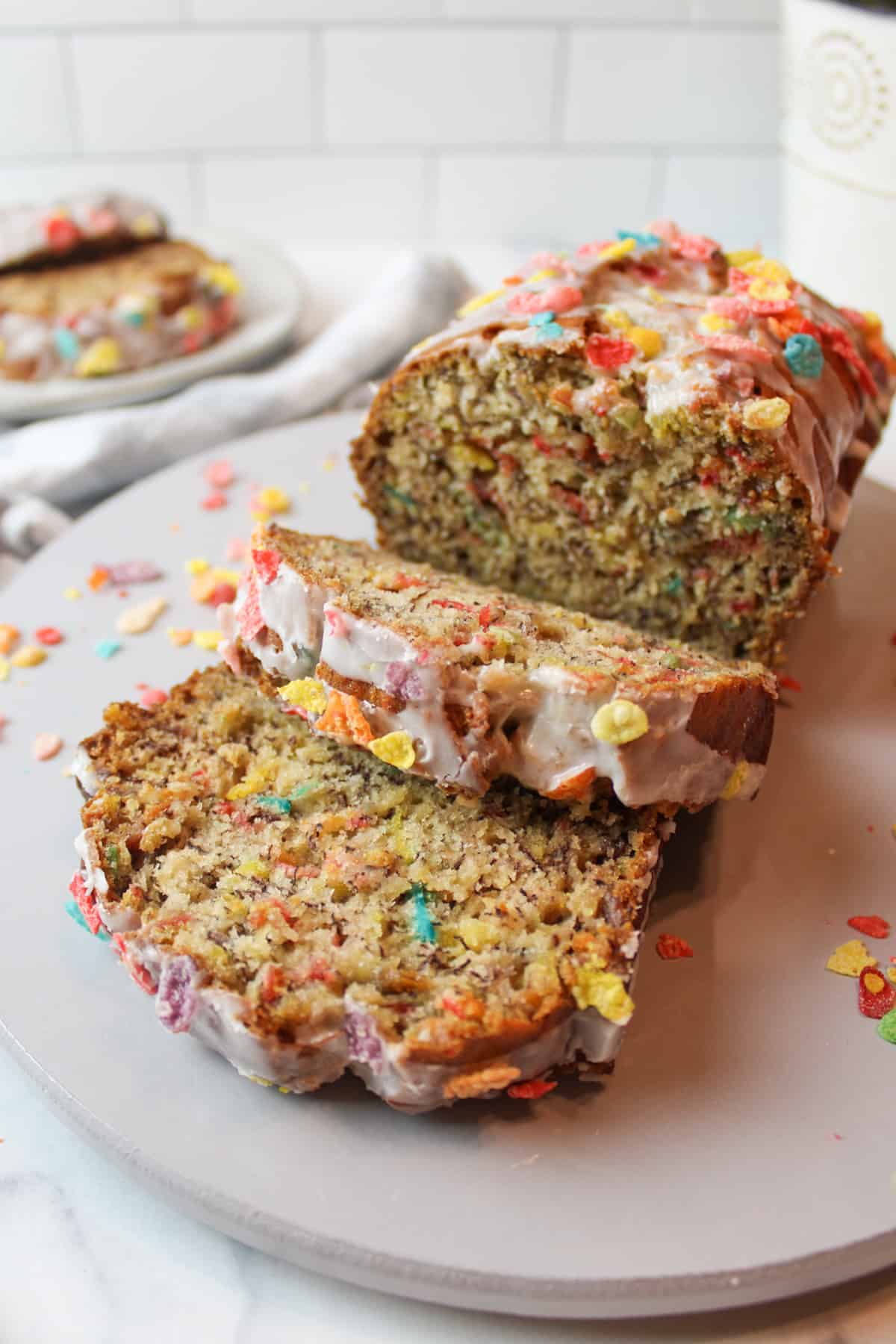 sliced fruity pebbles banana bread on a gray plate.